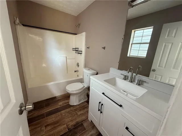 a bathroom with a sink toilet a mirror and shower