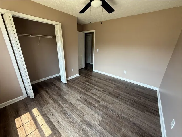an empty room with wooden floor and closet