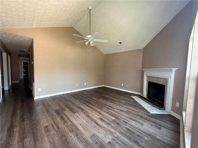 a view of empty room with wooden floor and fireplace