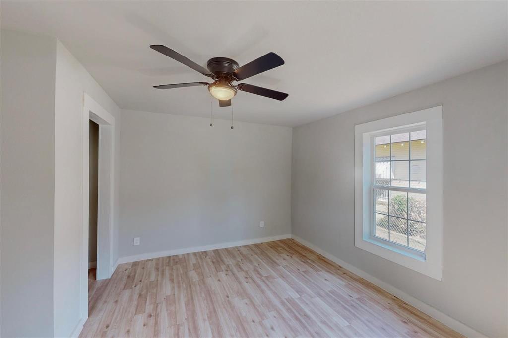 3603 York Street Dallas, TX 75210 - Photo 14 of 16 an empty room with wooden floor ceiling fan and windows