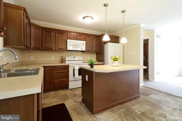 a kitchen with stainless steel appliances granite countertop a sink a stove and a wooden cabinets