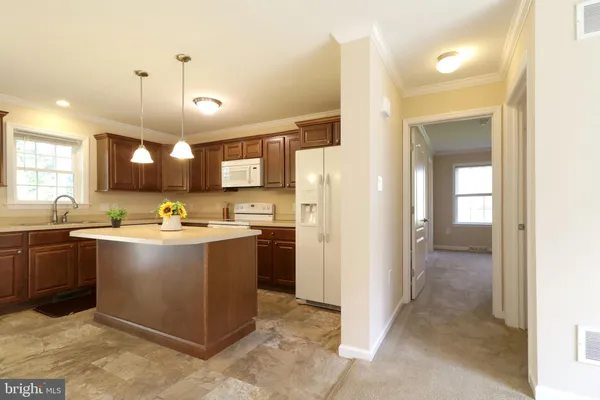 a large kitchen with a stove a refrigerator and a sink