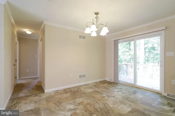 a view of a livingroom with a chandelier fan and windows