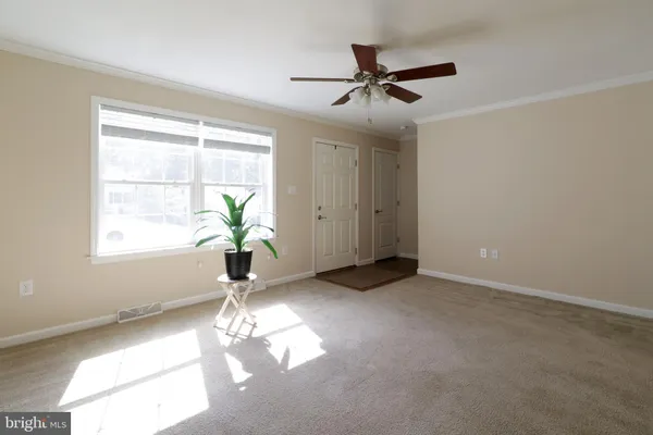 a view of empty room with window and ceiling fan