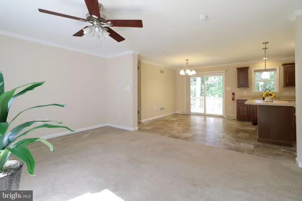 a view of a kitchen with a sink a ceiling fan and a window