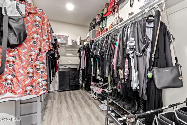 a view of walk in closet with clothes