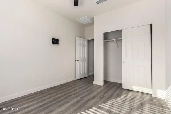 an empty room with wooden floor and closet