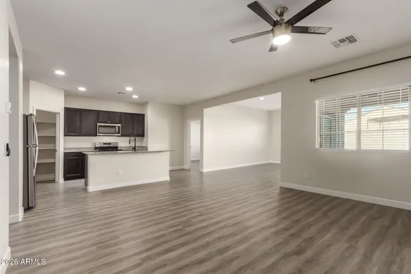a view of kitchen with stainless steel appliances refrigerator stove microwave and cabinets