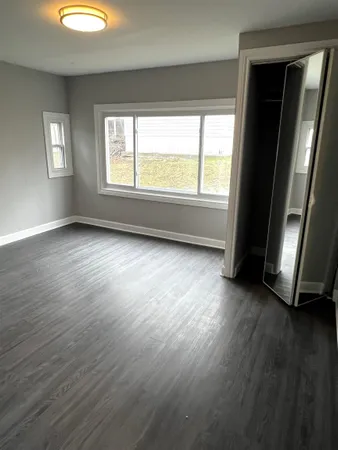 an empty room with wooden floor and windows