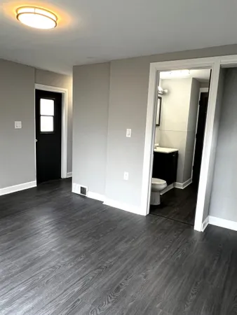 an empty room with wooden floor and closet