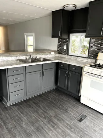 a kitchen with stainless steel appliances granite countertop a stove a sink and a microwave