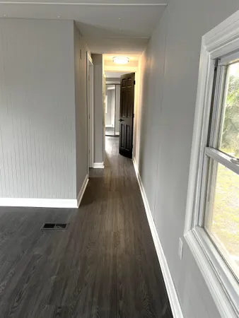 a view of a hallway with wooden floor and staircase