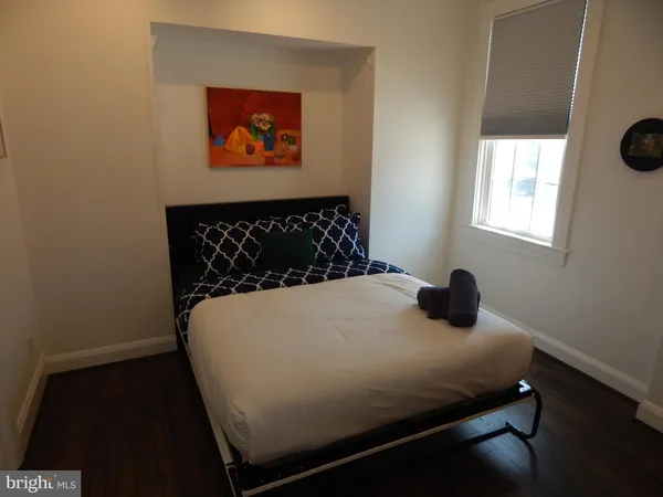 a bed sitting in a bedroom next to a window