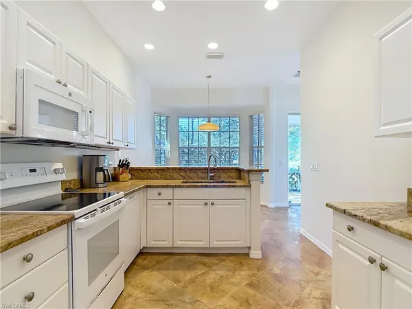 a kitchen with granite countertop a stove sink and cabinets