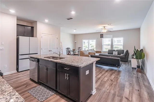 a kitchen with stainless steel appliances granite countertop a sink stove and refrigerator