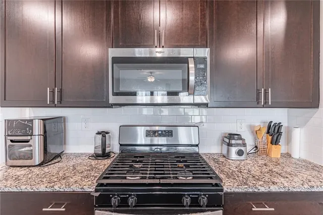 a kitchen with granite countertop stainless steel appliances and cabinets