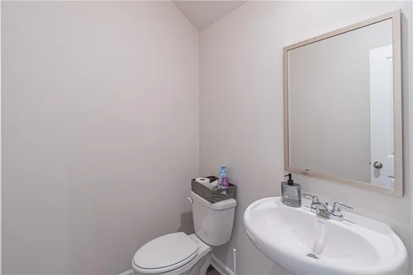 a bathroom with a sink a toilet and mirror