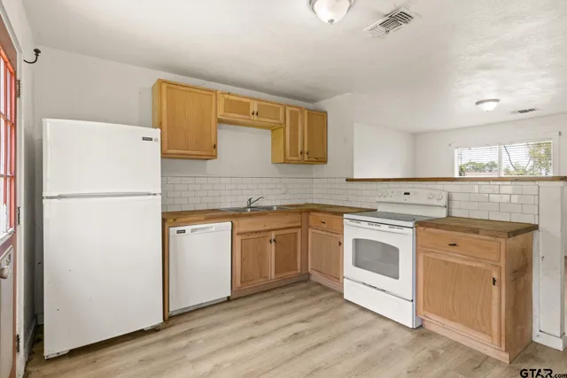 a kitchen with stainless steel appliances granite countertop a refrigerator sink and stove