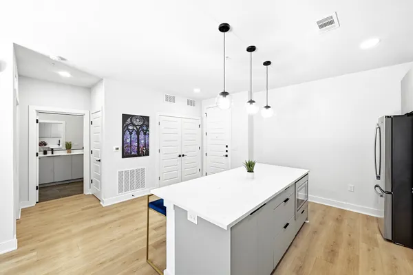 a kitchen with a sink a stove a refrigerator and white cabinets
