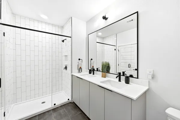 a bathroom with a shower sink and mirror