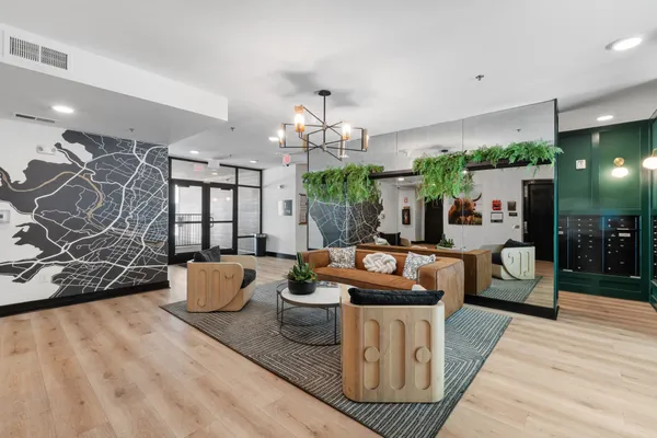 a living room with furniture a chandelier and a wooden floor