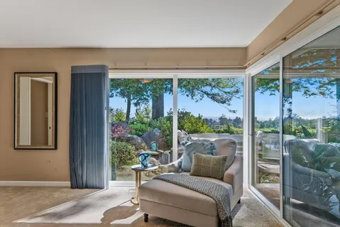 a living room with furniture and a floor to ceiling window