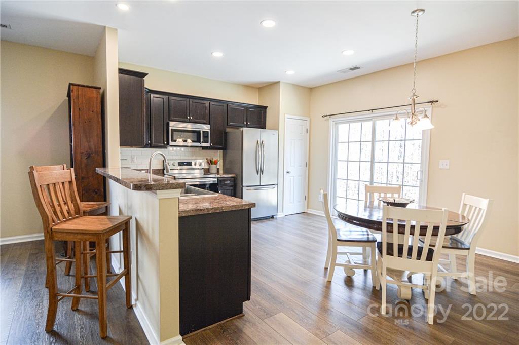 1617 Beleek Ridge Lane Clover, SC 29710 - Photo 9 of 22 a kitchen with stainless steel appliances kitchen island granite countertop a table chairs and a refrigerator
