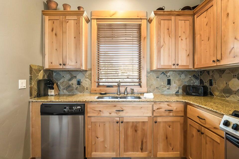 16845 South W Brasada Ranch Road, Unit 23 Powell Butte, OR 97753 - Photo 19 of 47 a kitchen with stainless steel appliances granite countertop a sink a stove and a microwave