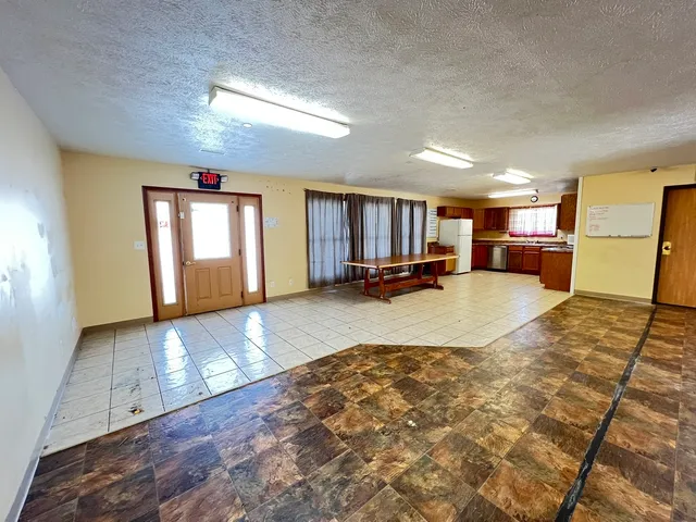 a kitchen with granite countertop a refrigerator stove top oven and sink