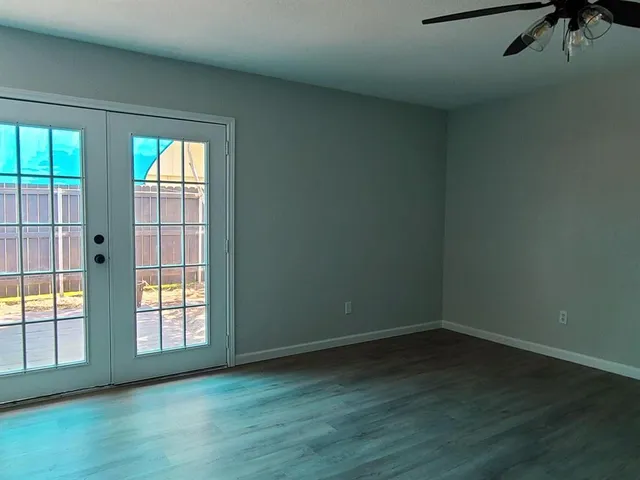 an empty room with wooden floor and windows