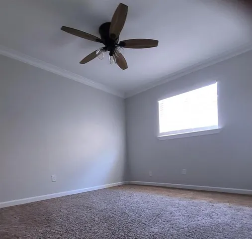 an empty room with a window and a ceiling fan