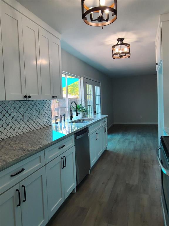 5036 Avery Lane The Colony, TX 75056 - Photo 6 of 22 a kitchen with stainless steel appliances granite countertop a sink a stove a chimney a counter space and cabinets