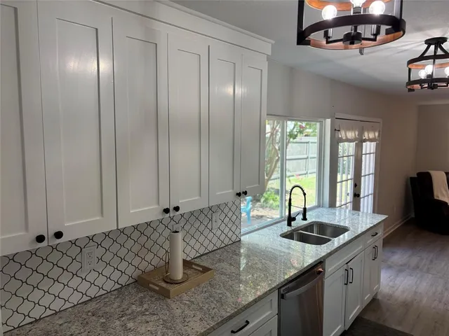 a kitchen with a sink window and cabinets