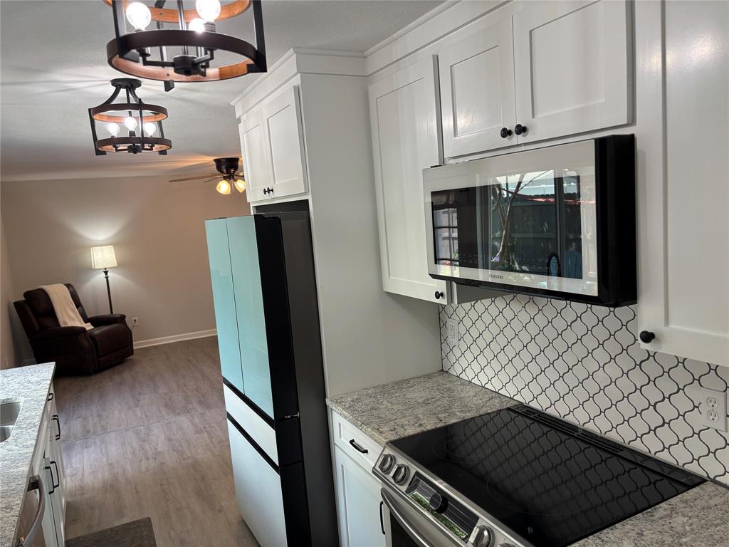 5036 Avery Lane The Colony, TX 75056 - Photo 8 of 22 a kitchen with granite countertop a stove and a refrigerator
