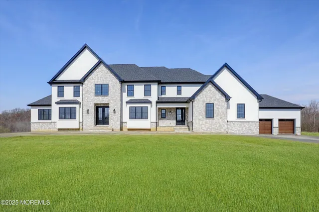 a front view of a house with a yard and trees