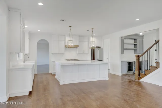 a large kitchen with stainless steel appliances kitchen island a stove a sink a refrigerator and a center island