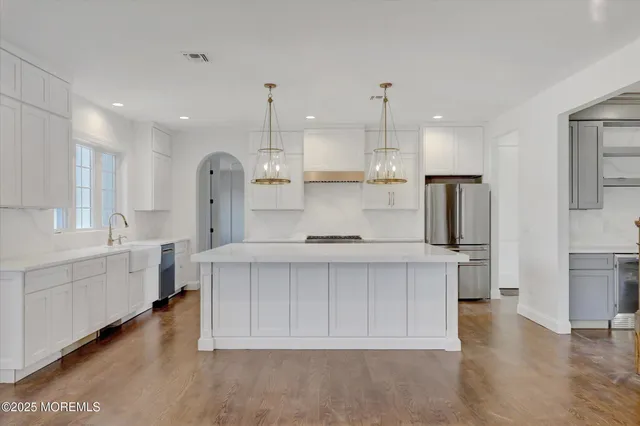 a view of an empty room with wooden floor and windows