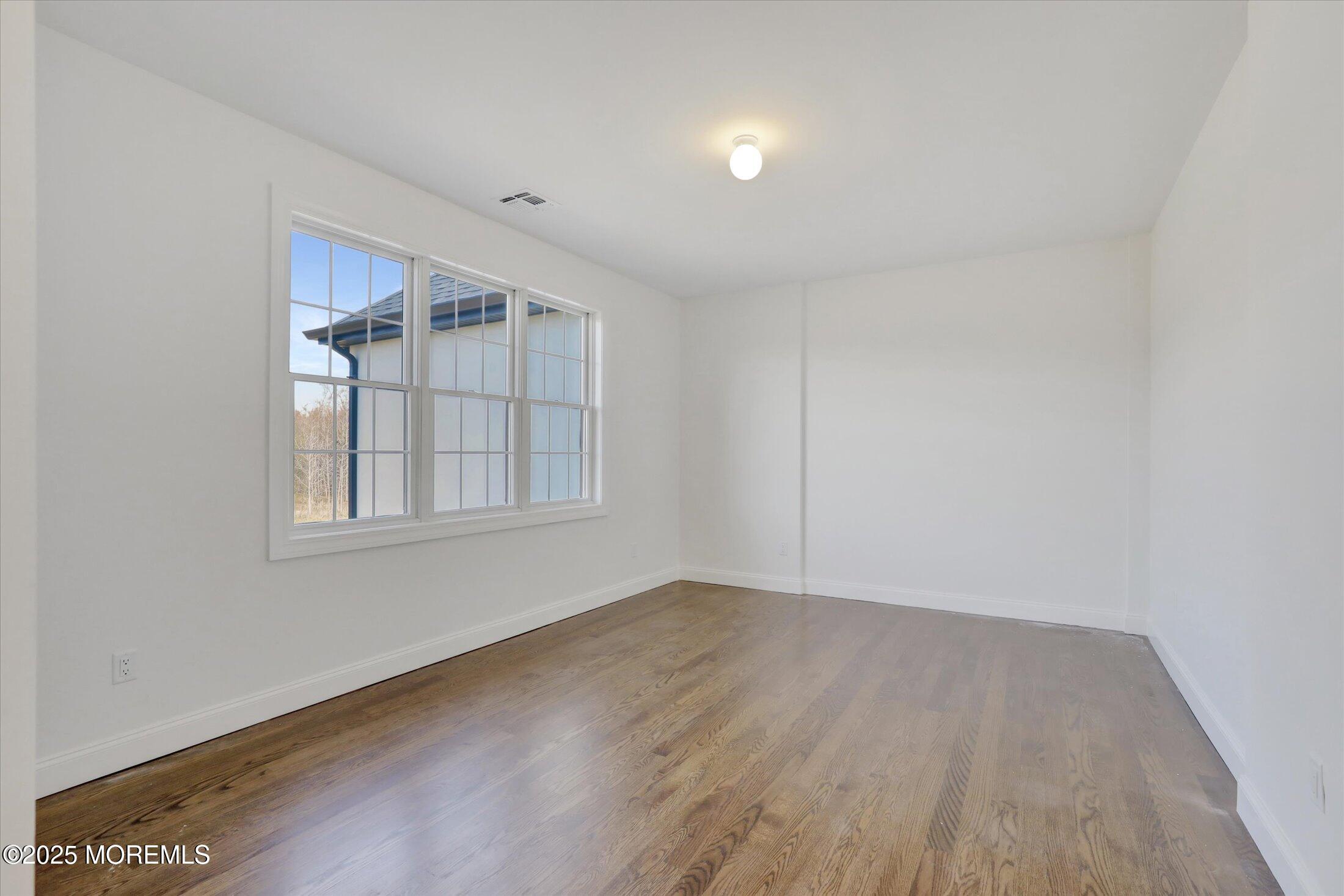 11 Cook Court Millstone Township, NJ 08535 - Photo 43 of 64 an empty room with wooden floor and windows