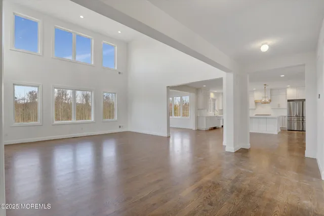 a view of empty room with wooden floor and windows