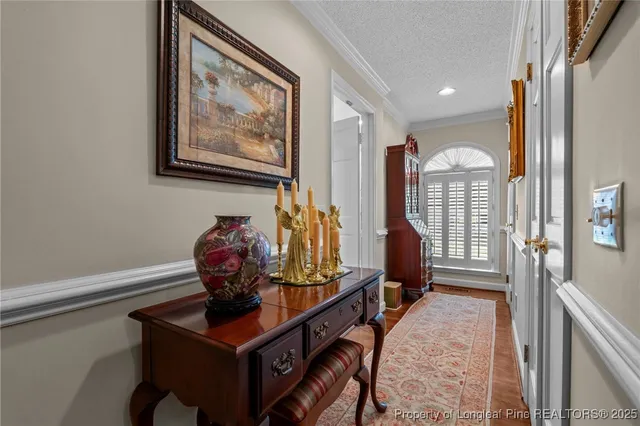 a view of a hallway with furniture and a window