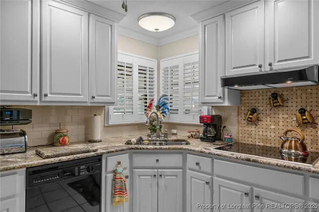 a kitchen with granite countertop a sink stainless steel appliances and cabinets