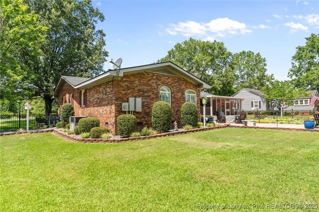 a view of a house with a yard and sitting area