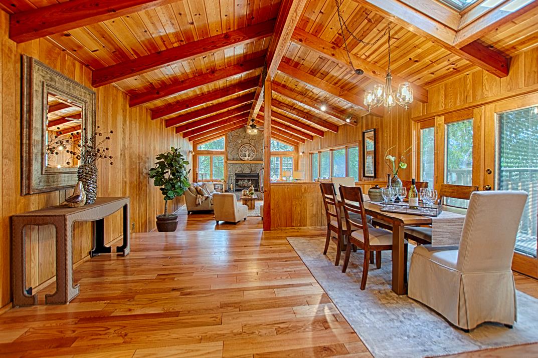 a dining hall with couches a dining table and chairs with wooden floor