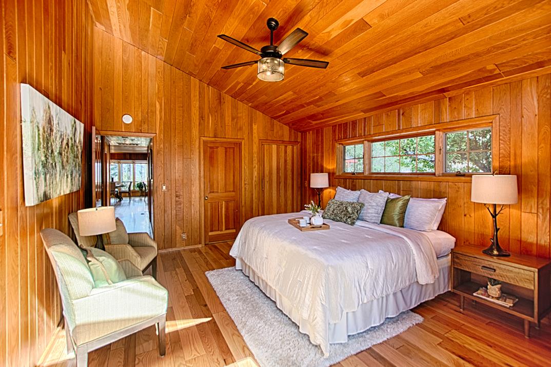 79 Pine Avenue Mount Hermon, CA 95041 - Photo 14 of 32 a bedroom with a bed a chandelier and a potted plant