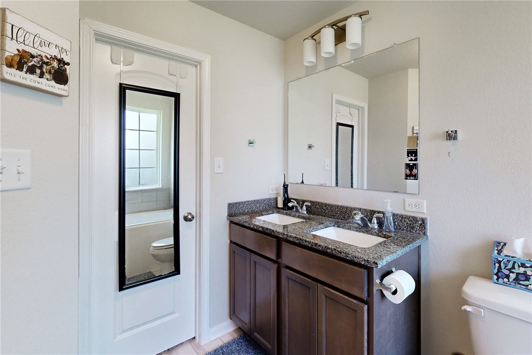 3719 Mckenzie Street Bryan, TX 77803 - Photo 16 of 20 a bathroom with a granite countertop sink and a mirror