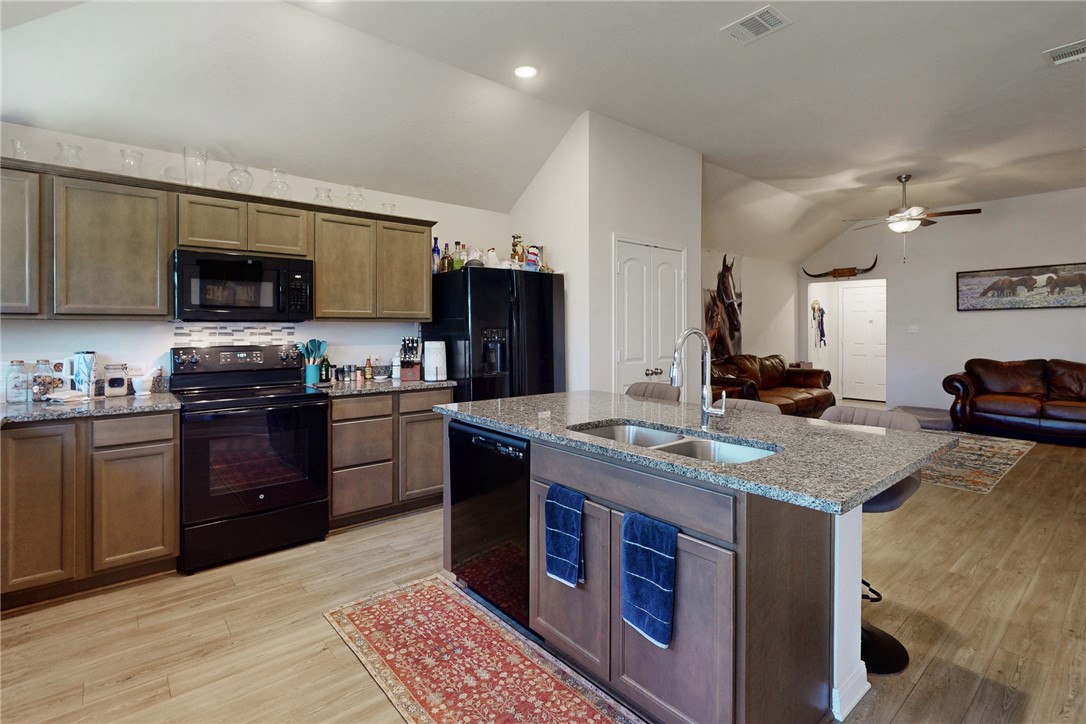3719 Mckenzie Street Bryan, TX 77803 - Photo 8 of 20 a kitchen with stainless steel appliances granite countertop a sink stove microwave and refrigerator