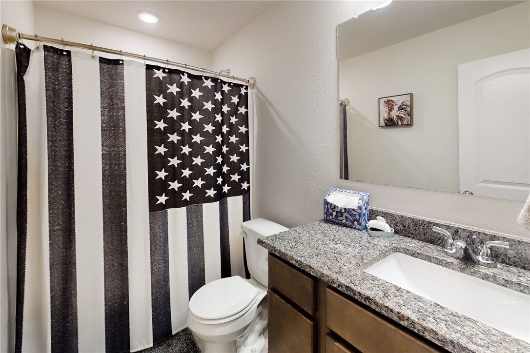 3719 Mckenzie Street Bryan, TX 77803 - Photo 10 of 20 a bathroom with a granite countertop sink toilet and shower