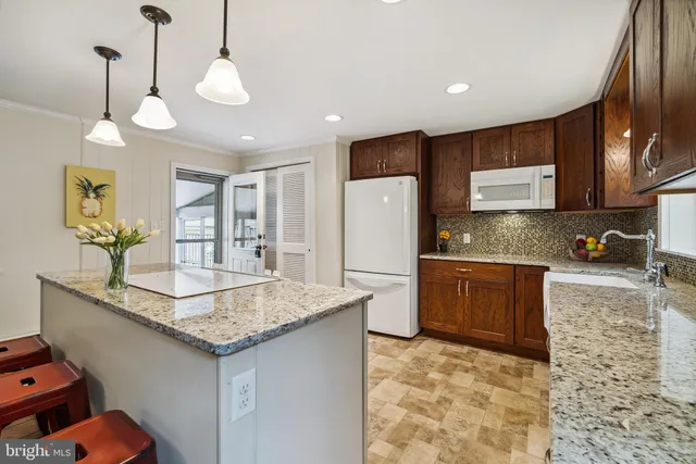 a kitchen with stainless steel appliances granite countertop a sink refrigerator and cabinets