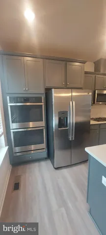 a kitchen with stainless steel appliances granite countertop a sink a stove and a refrigerator