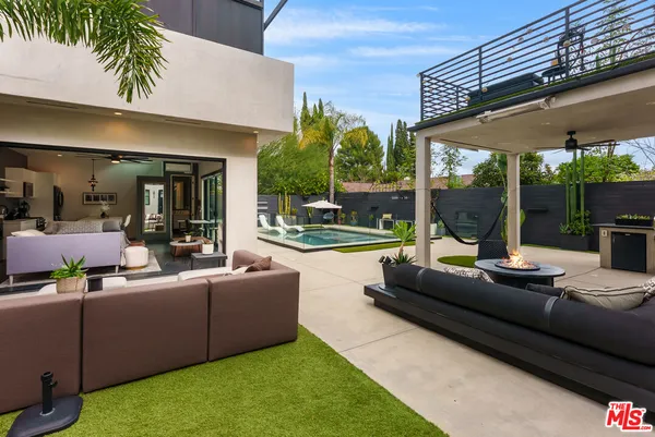 a living room with furniture a large window and a chandelier